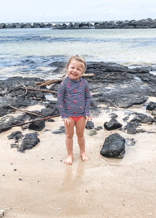 Young girl posing on Onekahakah Beach Park in Hilo, Hawaii