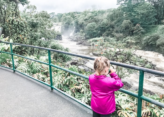 Young girl admiring waterfalls on the Big Island in Hawaii