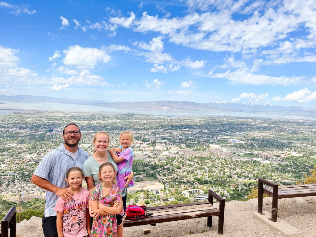 Family hiking with a view of Provo behind them.