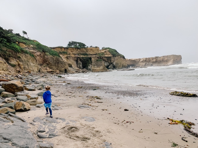 Girl walking on the beach near the Devils Punchbowl