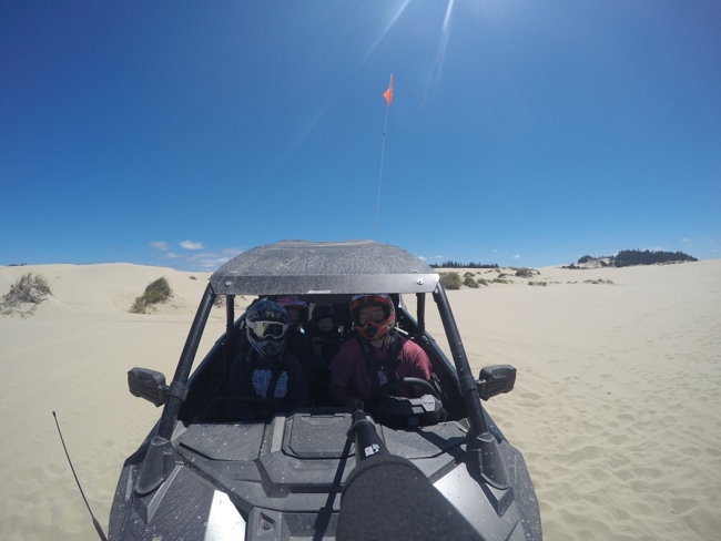 A family riding a side by side at the Oregon Dunes National recreation area.