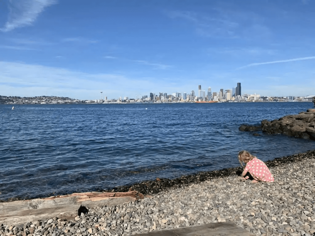 Girl on the beach with the Seattle skyline in the back