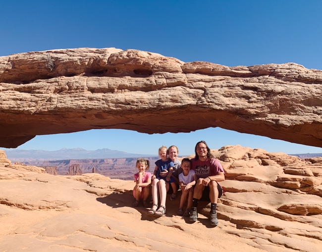 Family in front of Mesa Arch in Canyonlands