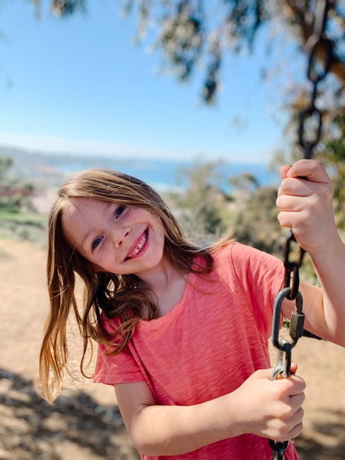 Girl on a swing overlooking the ocean