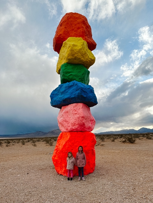 Kids standing in front of one pillar in Seven Magic Mountains