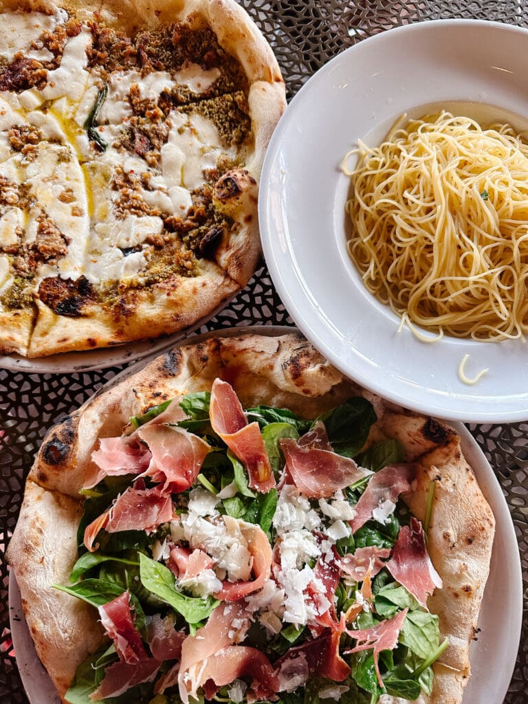 Table covered in pizza and pasta dishes from Antica Forma, one of the best Moab restaurants.