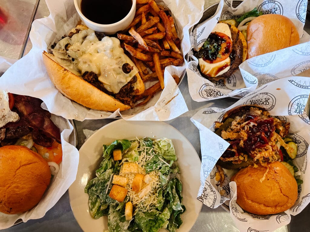 A table full of burgers, fries and salad from Spoke on Center, one of the best Moab restaurants.