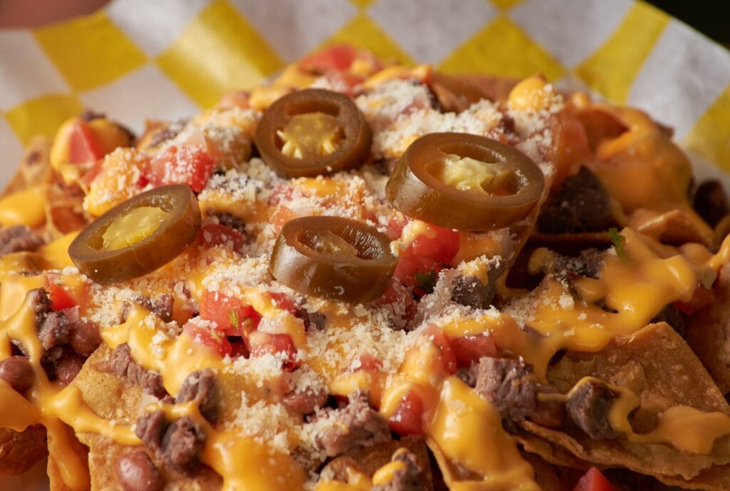 Nachos with jalapenos, meat, and tomatoes