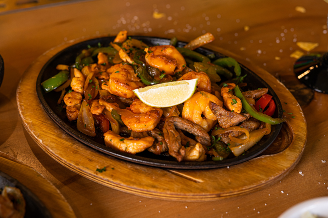 Cast iron skillet at The Matador full of steak, shrimp and peppers for fajitas.