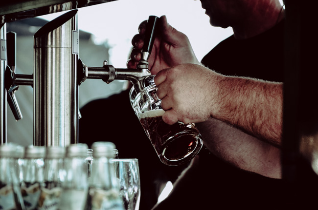 A man filling a glass a beer during the Winter Beer Festival, one of the best events happening in Seattle in December.