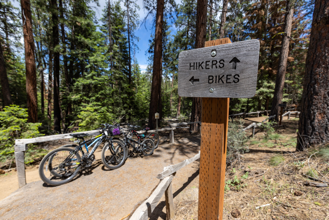 Sign directing hikers and bikers on a trail.