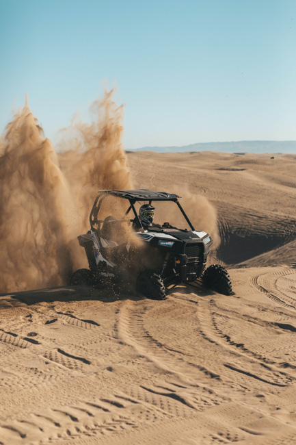 Buggy driving through deep sand through the desert.