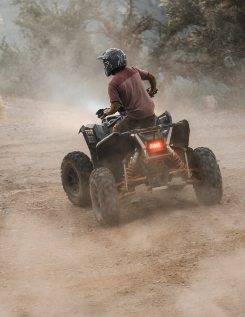 Man riding an ATV through the desert.