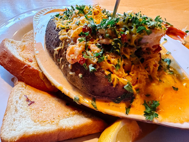 A loaded baked potato and toasted bread on a plate.