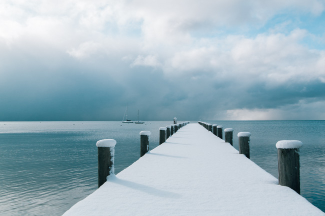 Snowy boardwalk leading to Lake Tahoe.