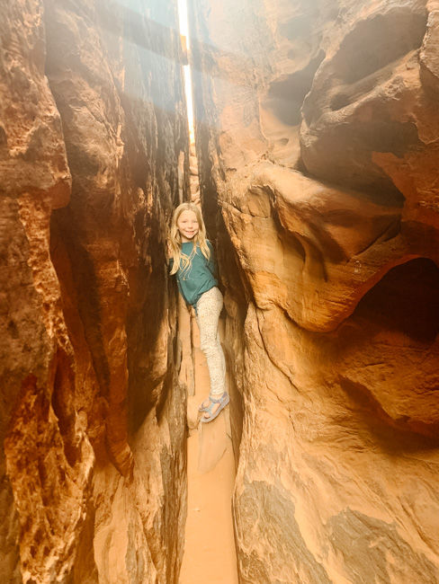 My daughter climbing through a slot canyon at Pioneer Park, one of her favorite things to do in St. George, Utah